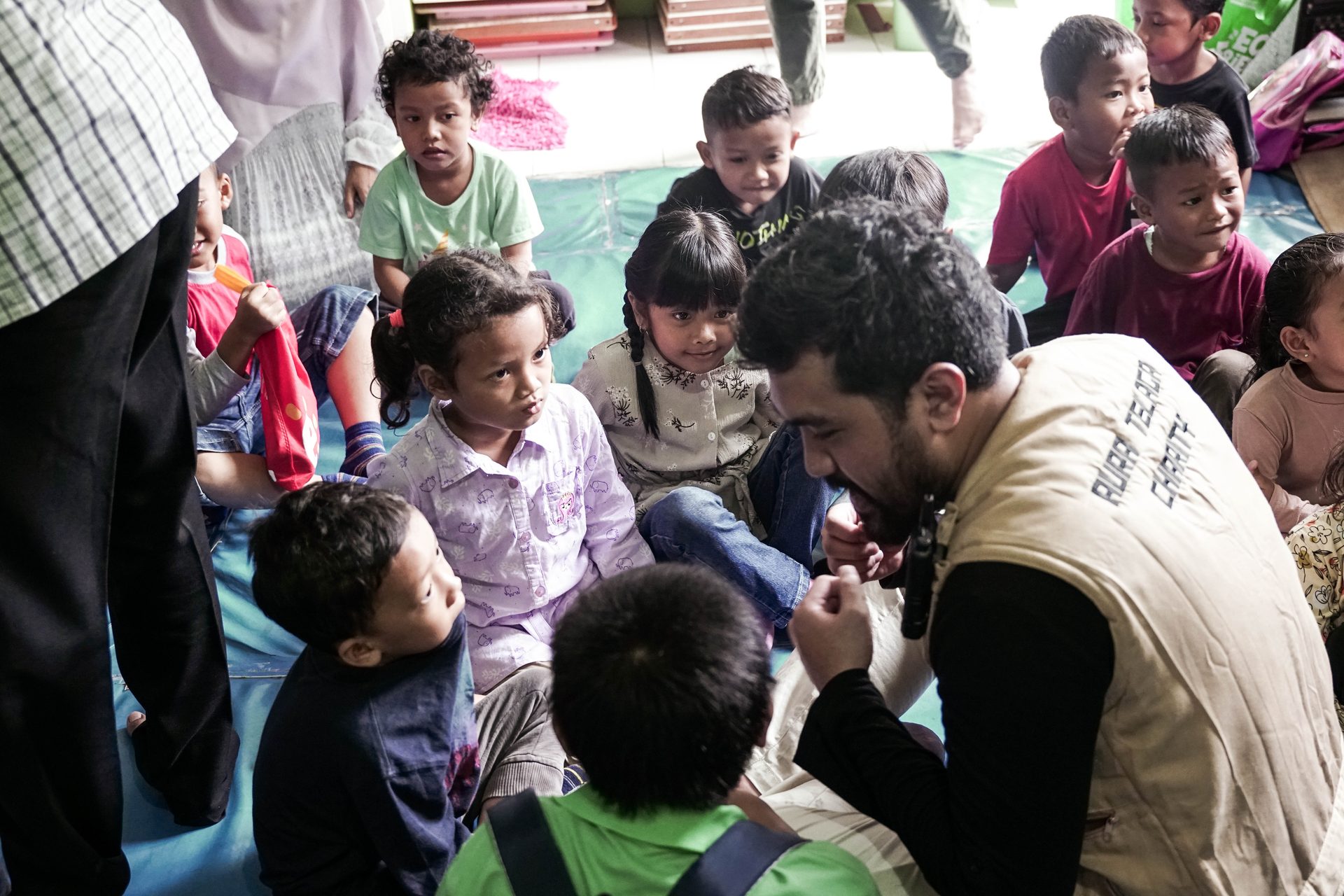 Telaga Charity volunteers in a circle with children in Indonesia